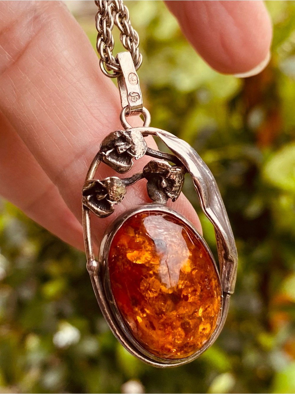 Silver Amber Pendant Necklace with Warm Honey Amber natural sparkles in light.